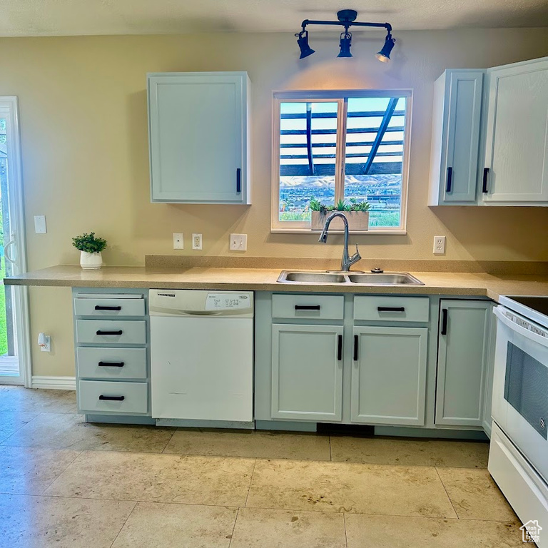 Kitchen with sink, white appliances, and light tile patterned floors