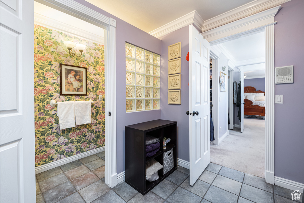 Hall featuring tile patterned flooring and ornamental molding