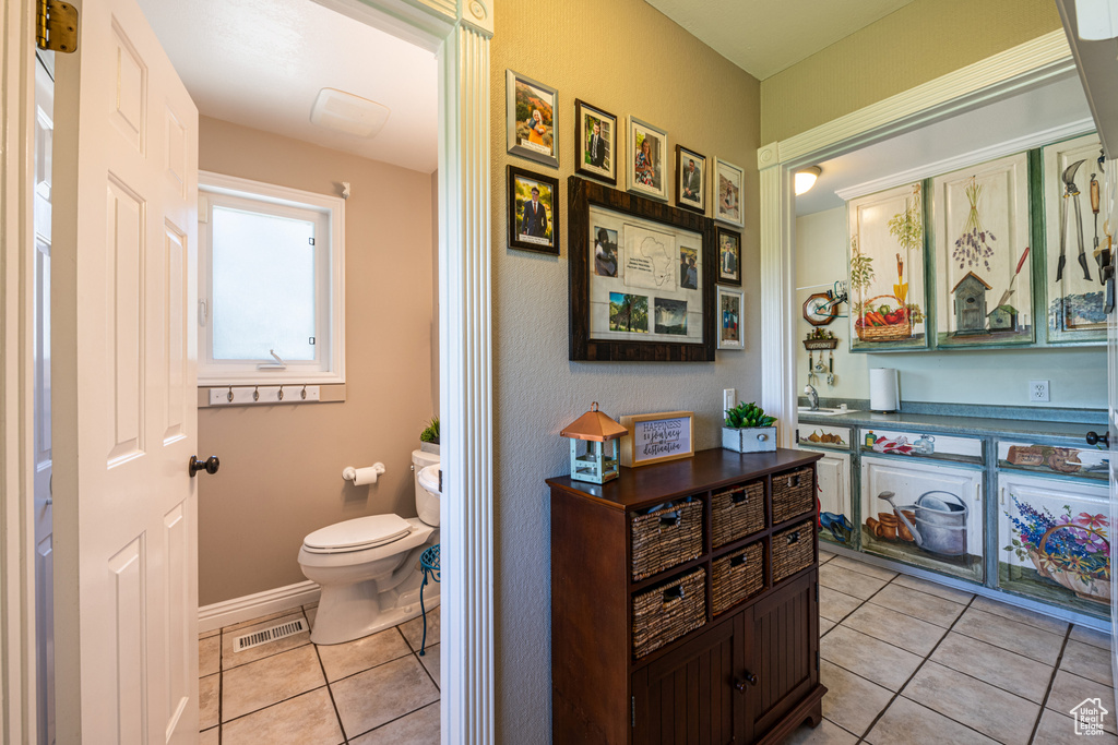 Bathroom featuring vanity, tile patterned flooring, and toilet