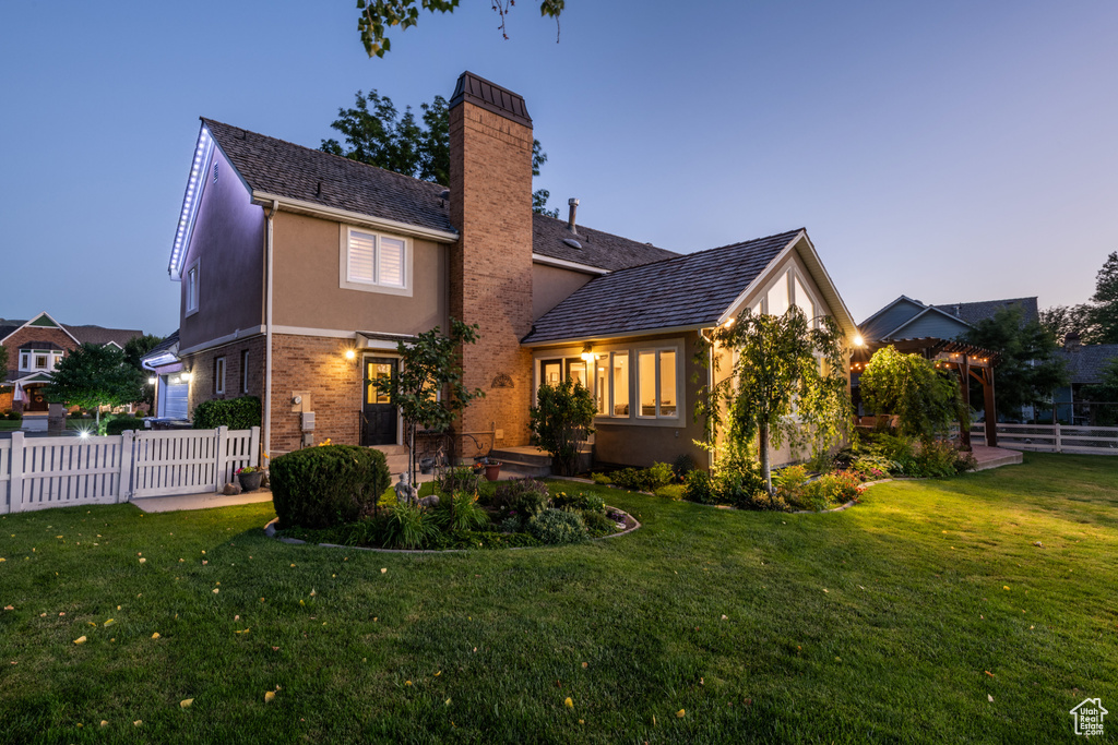 Rear view of house featuring a lawn