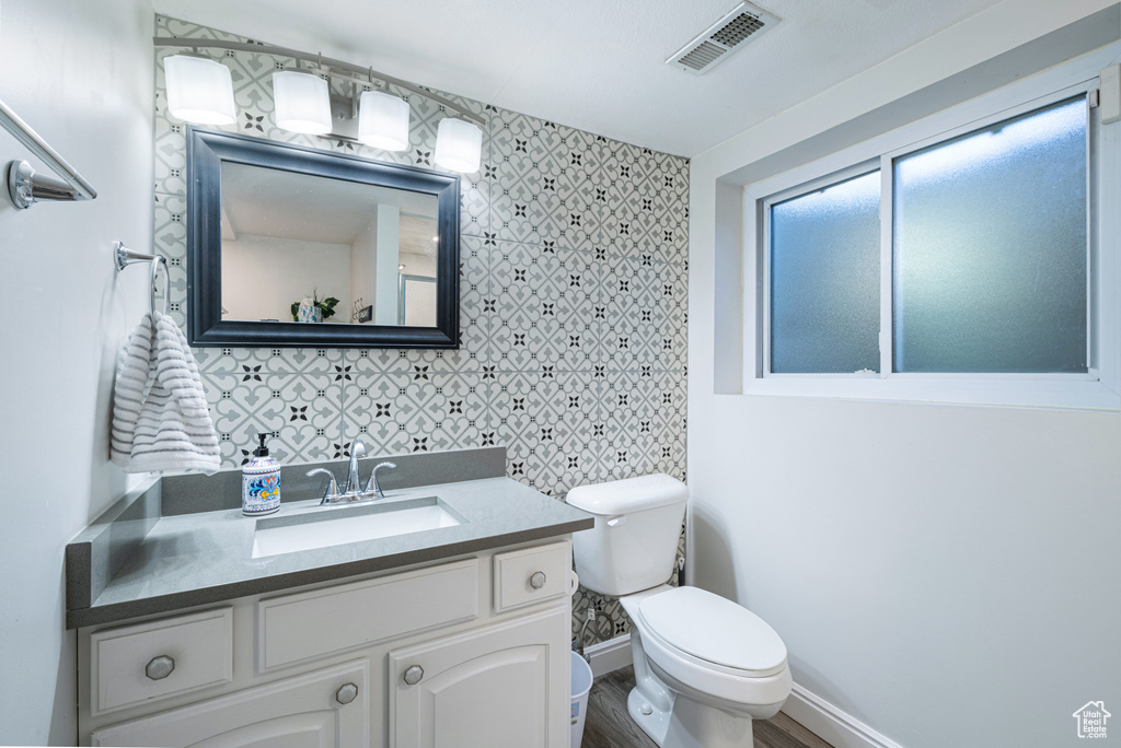 Bathroom with vanity, toilet, hardwood / wood-style floors, and tile walls