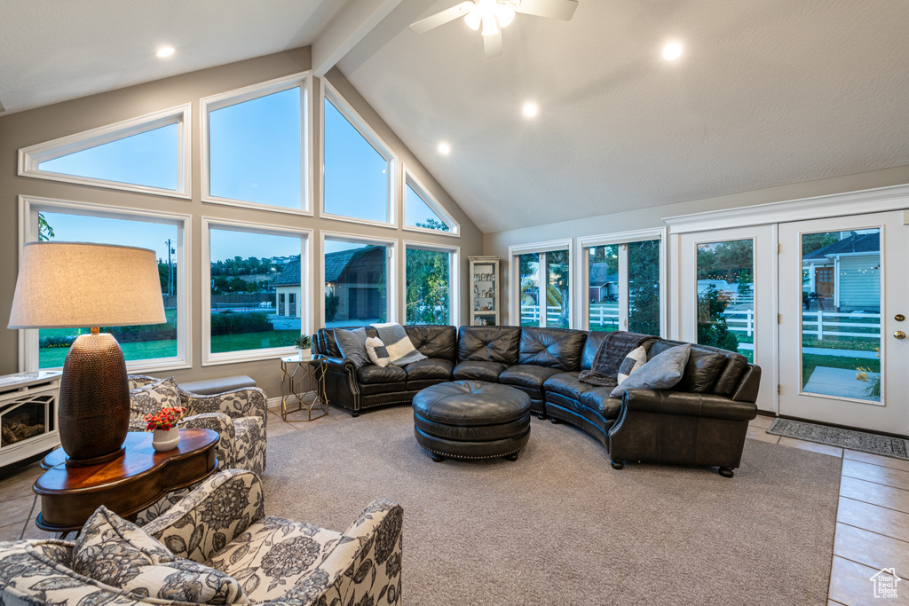 Tiled living room featuring beam ceiling, ceiling fan, and high vaulted ceiling