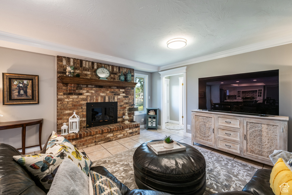 Tiled living room featuring ornamental molding, a fireplace, and brick wall