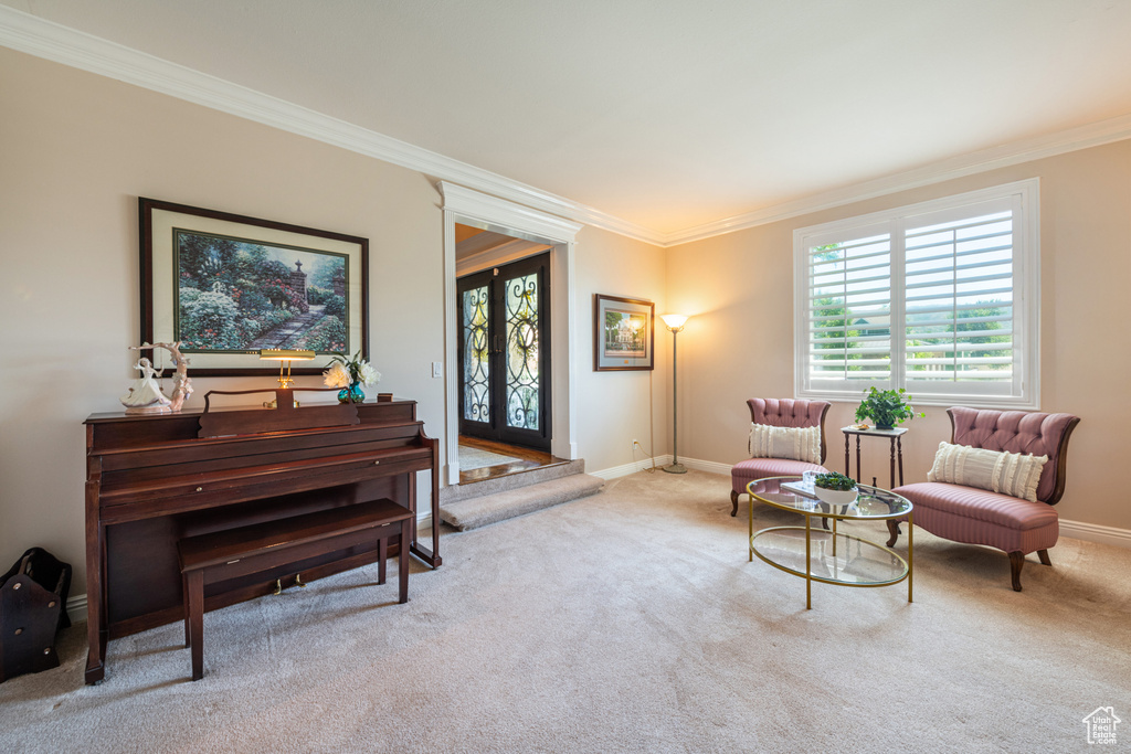 Sitting room with carpet flooring, crown molding, and french doors