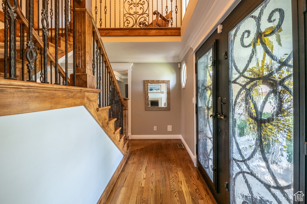 Entryway with french doors, hardwood / wood-style flooring, and ornamental molding