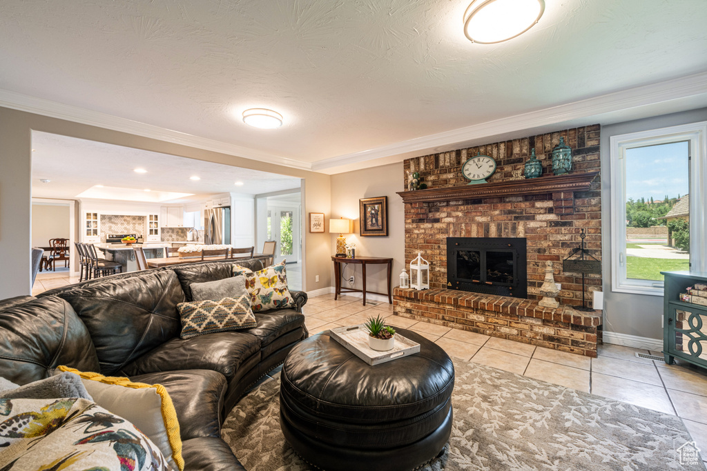 Tiled living room with a fireplace and crown molding