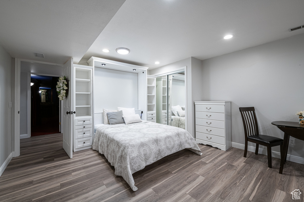 Bedroom featuring dark wood-type flooring and a closet