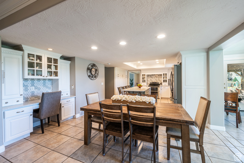 Dining space with a textured ceiling and light tile patterned floors