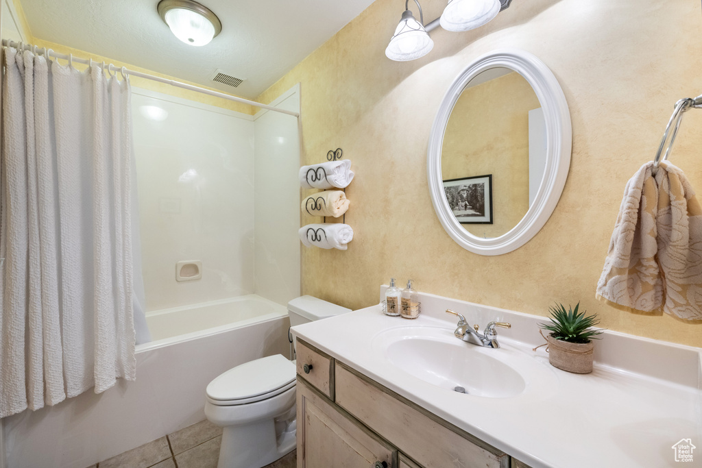 Full bathroom featuring tile patterned floors, vanity, shower / bath combo with shower curtain, and toilet