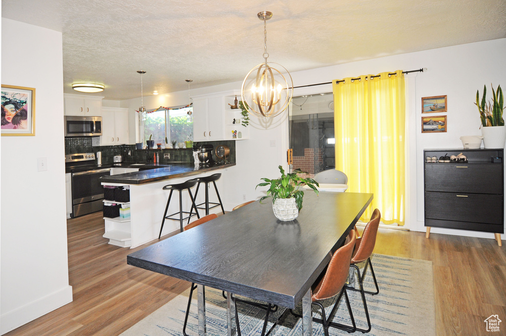 Dining area with a notable chandelier and hardwood / wood-style floors