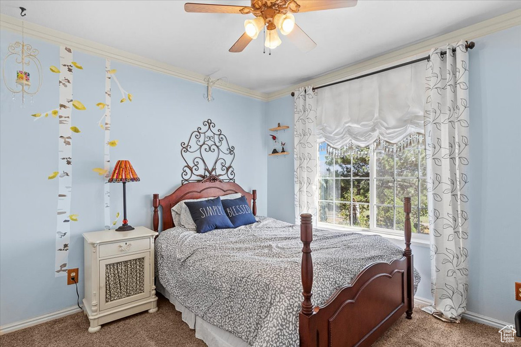 Carpeted bedroom with crown molding and ceiling fan