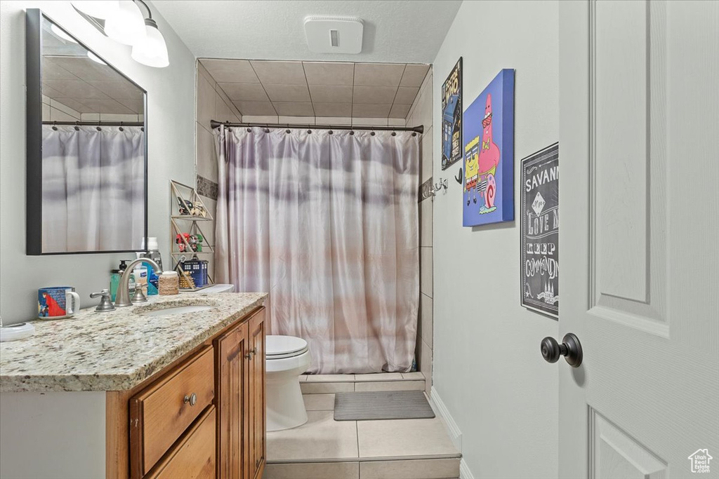 Bathroom featuring vanity, tile patterned flooring, and toilet