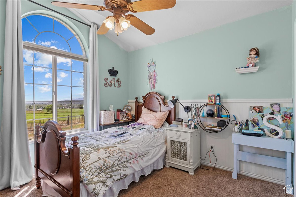 Carpeted bedroom featuring lofted ceiling and ceiling fan