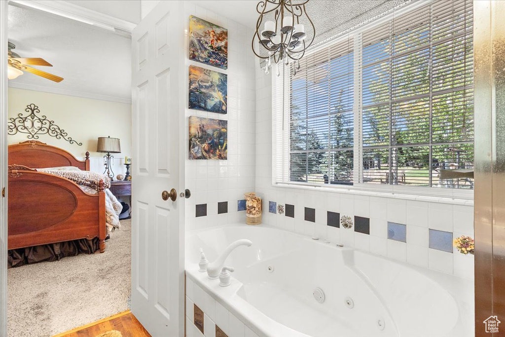 Bathroom with ceiling fan with notable chandelier and ornamental molding