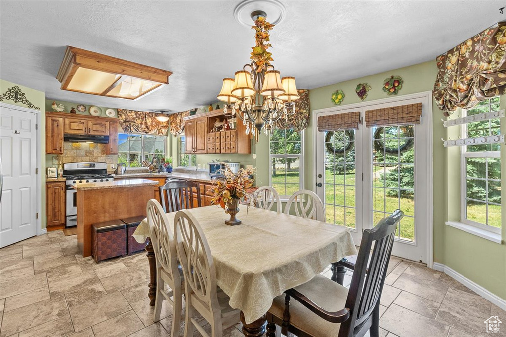 Tiled dining area featuring a chandelier and a wealth of natural light