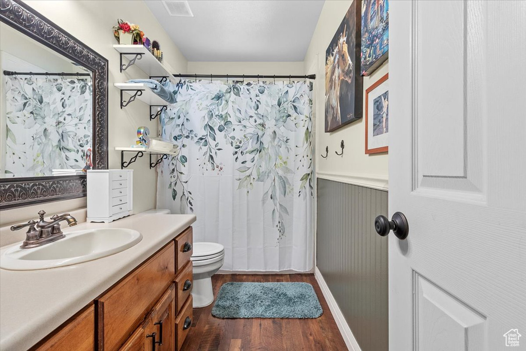 Bathroom featuring vanity, wood-type flooring, and toilet