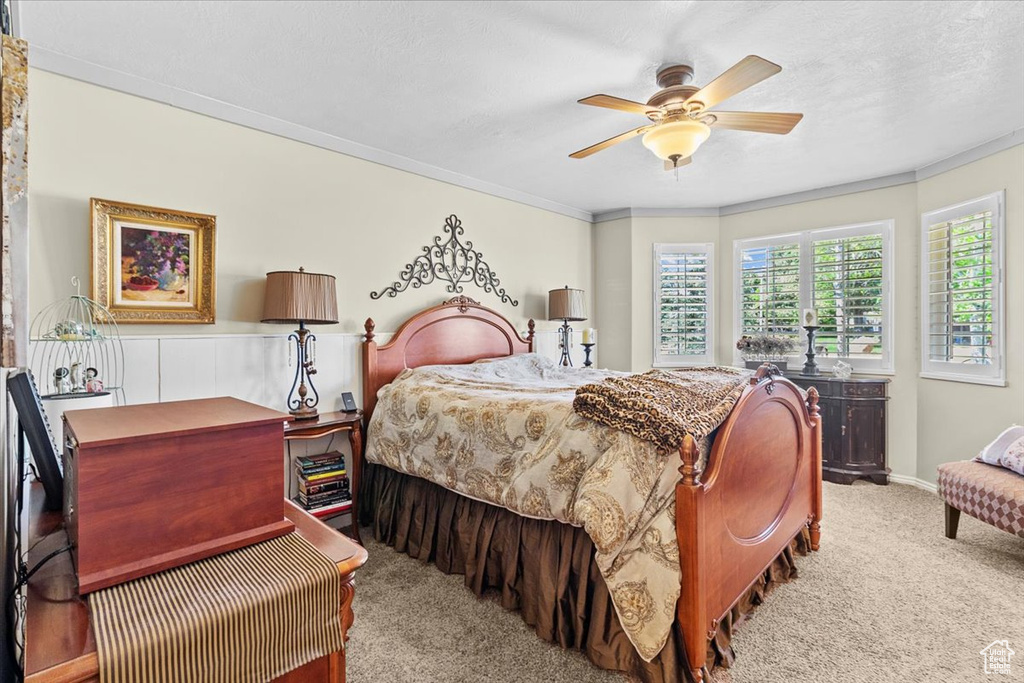 Carpeted bedroom with crown molding and ceiling fan