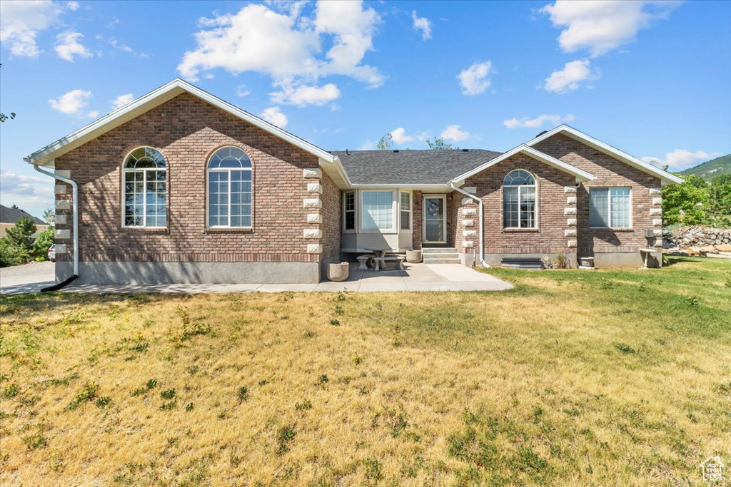 Ranch-style home with a patio area and a front lawn