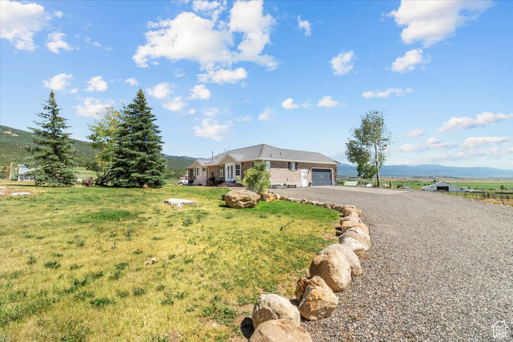 Ranch-style home featuring a garage and a front lawn