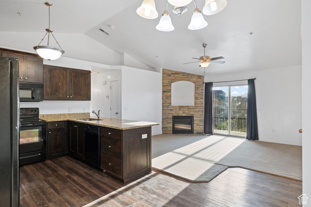 Kitchen with dishwashing machine, refrigerator, dark colored carpet, a fireplace, and stove