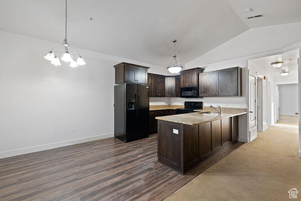 Kitchen featuring decorative light fixtures, black appliances, carpet, and dark brown cabinetry