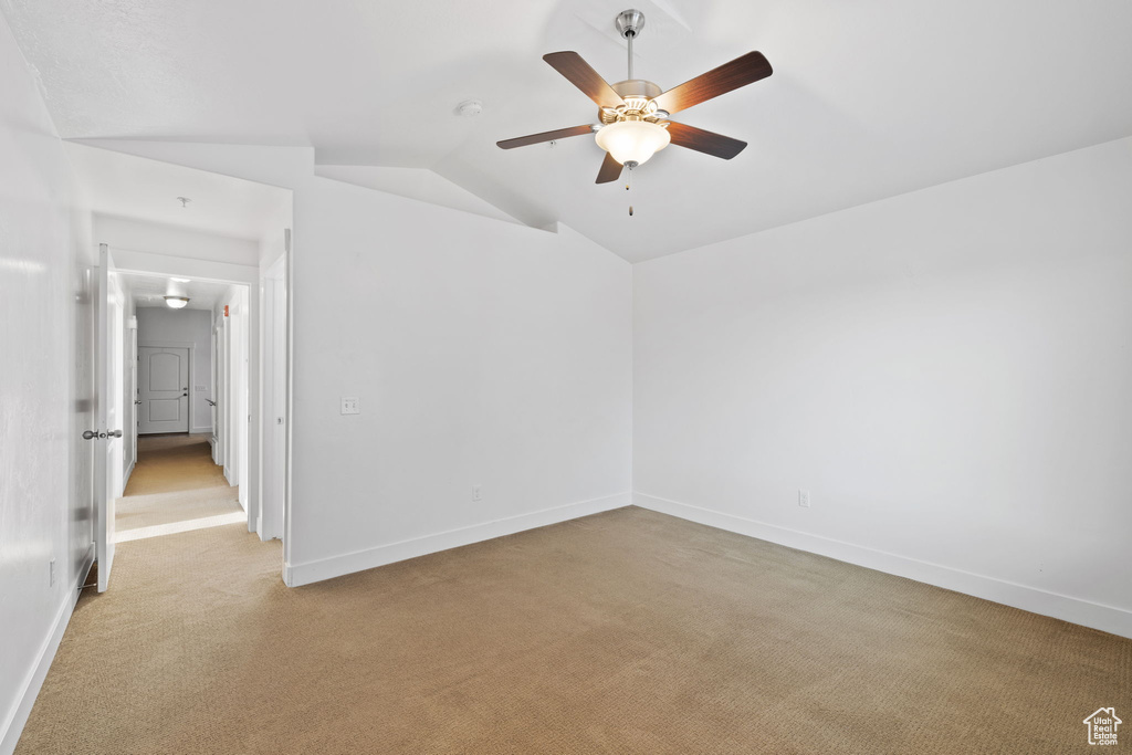 Unfurnished room with vaulted ceiling, light colored carpet, and ceiling fan