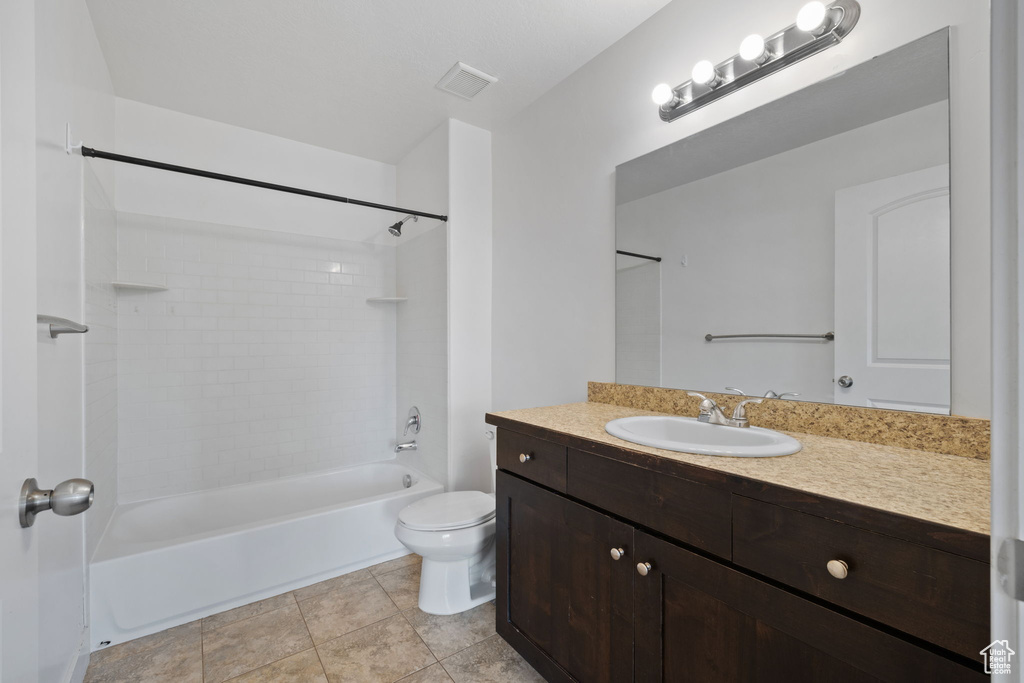 Full bathroom featuring tile patterned flooring, toilet, tiled shower / bath combo, and vanity