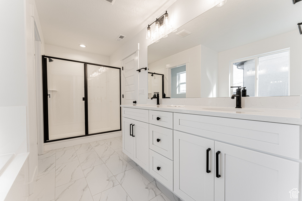 Bathroom featuring vanity and a shower with shower door