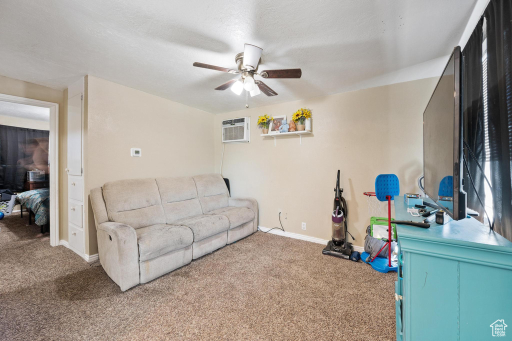 Living room featuring an AC wall unit, ceiling fan, and carpet floors