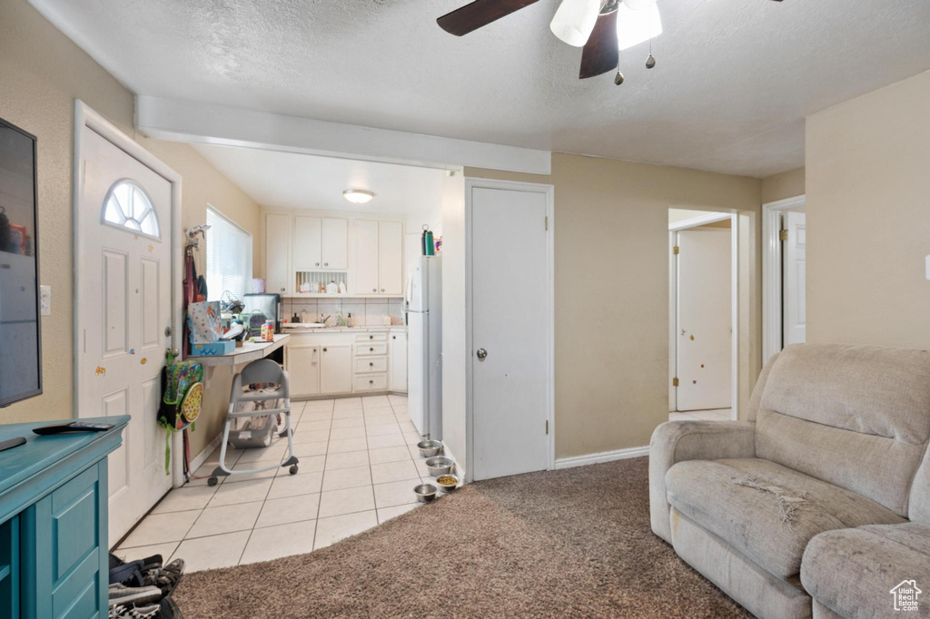 Carpeted living room featuring sink, a textured ceiling, and ceiling fan