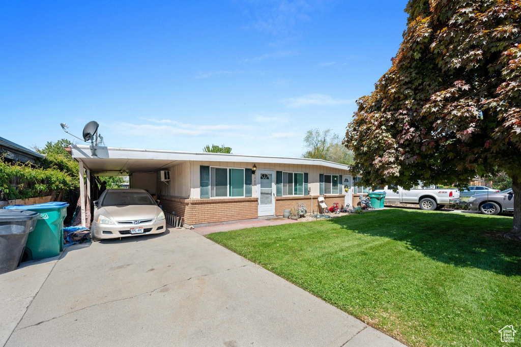 View of front facade with a front yard and a carport