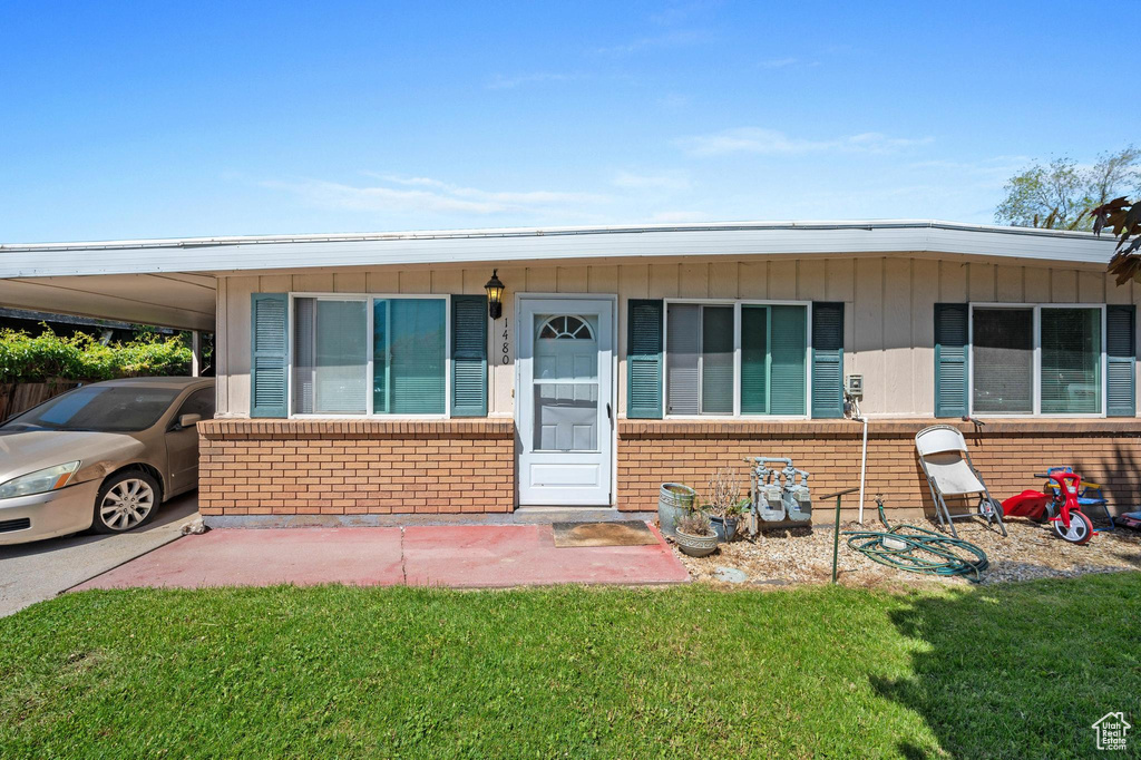 View of front of house featuring a carport and a front yard