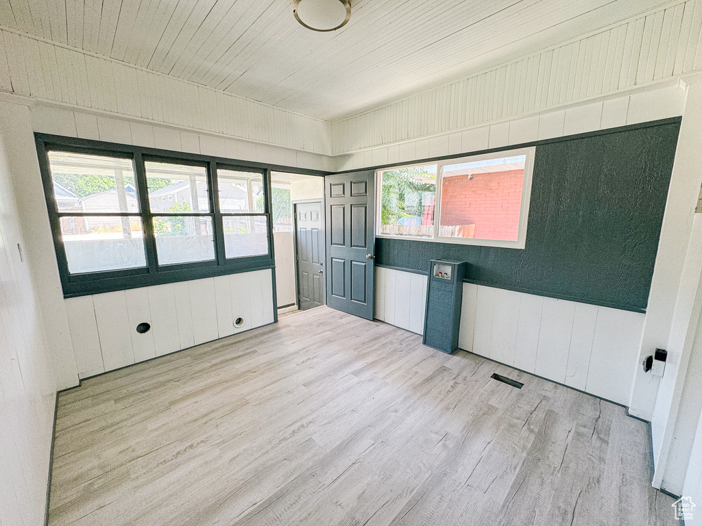 Spare room featuring light hardwood / wood-style flooring and plenty of natural light