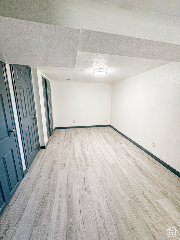 Unfurnished bedroom with a textured ceiling and light hardwood / wood-style flooring