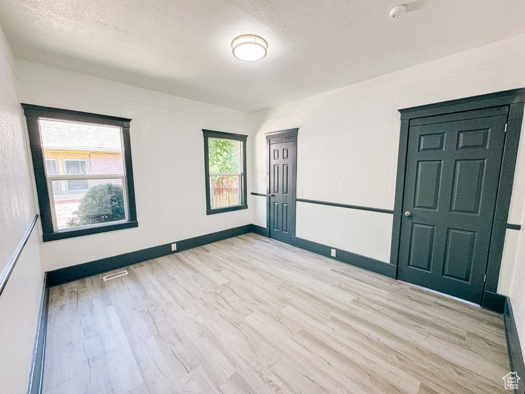 Spare room featuring a textured ceiling and light wood-type flooring