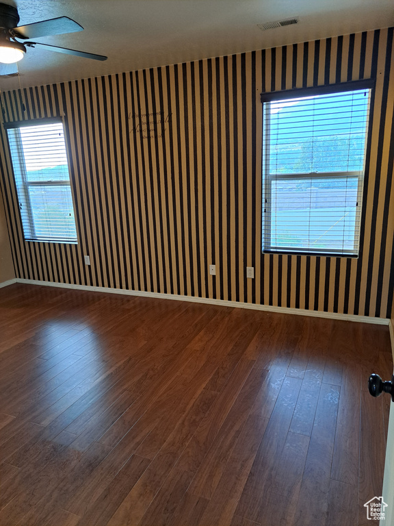 Empty room with ceiling fan and hardwood / wood-style floors