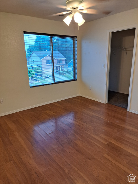 Unfurnished bedroom featuring a closet, hardwood / wood-style flooring, and ceiling fan