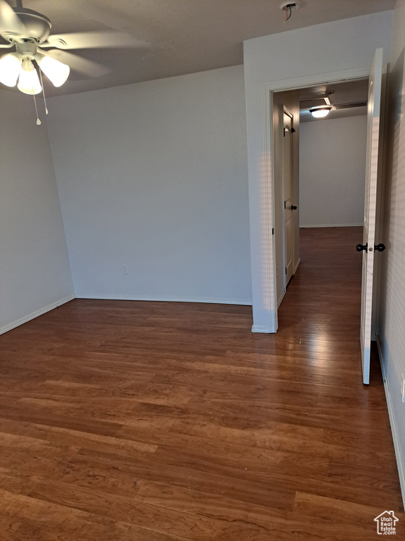 Spare room with dark hardwood / wood-style floors and ceiling fan