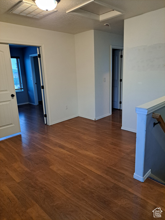 Spare room with dark wood-type flooring and a textured ceiling