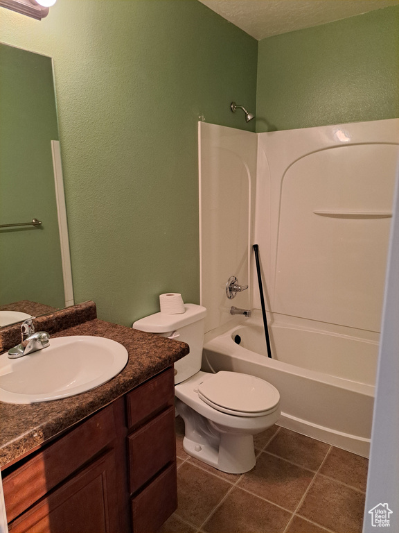 Full bathroom with vanity, toilet,  shower combination, and tile patterned floors