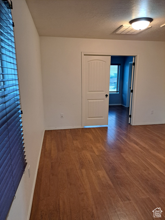 Unfurnished room featuring a textured ceiling and hardwood / wood-style floors