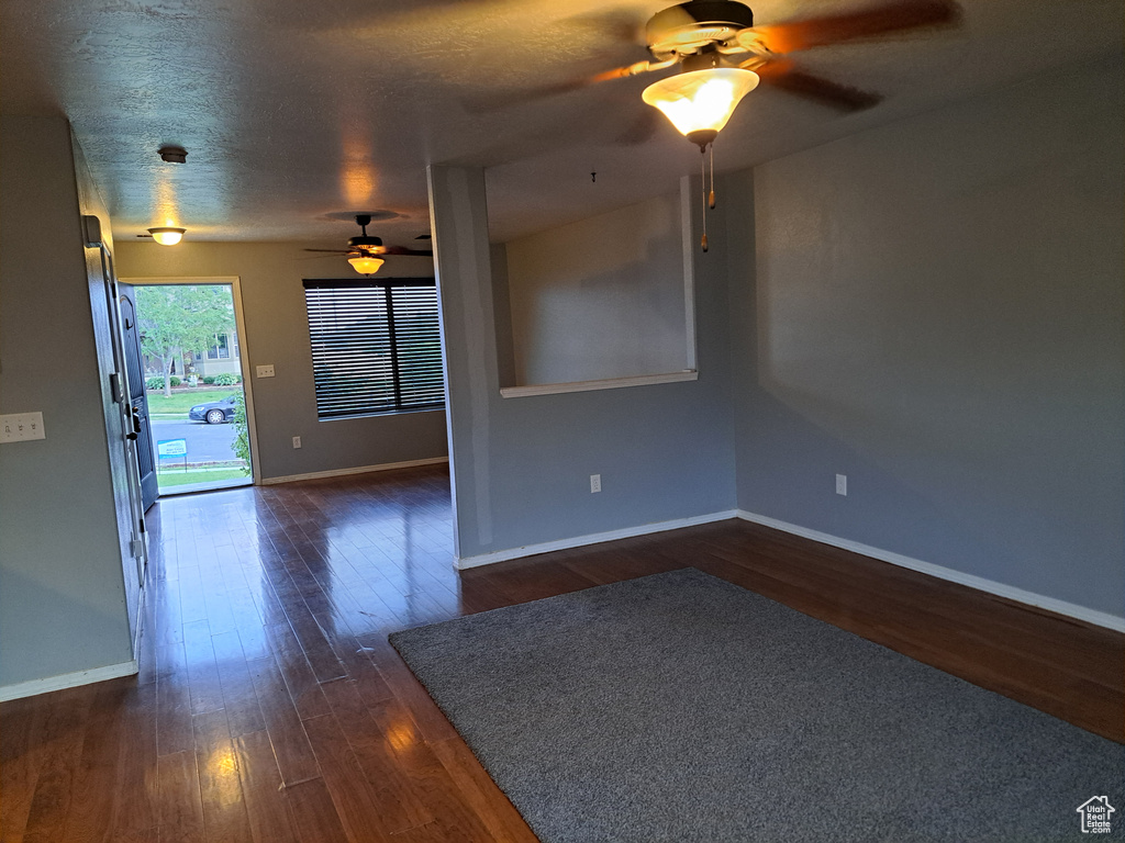 Spare room with dark hardwood / wood-style flooring, a textured ceiling, and ceiling fan