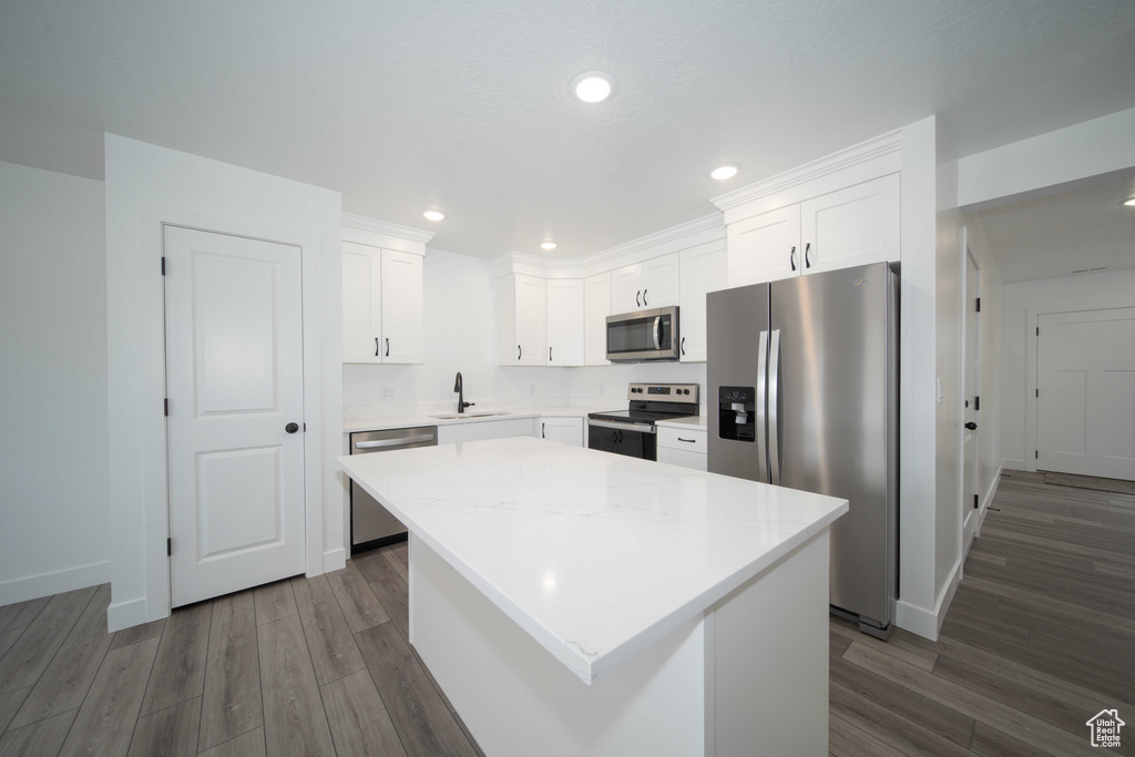 Kitchen featuring white cabinetry, a kitchen island, appliances with stainless steel finishes, dark hardwood / wood-style floors, and sink