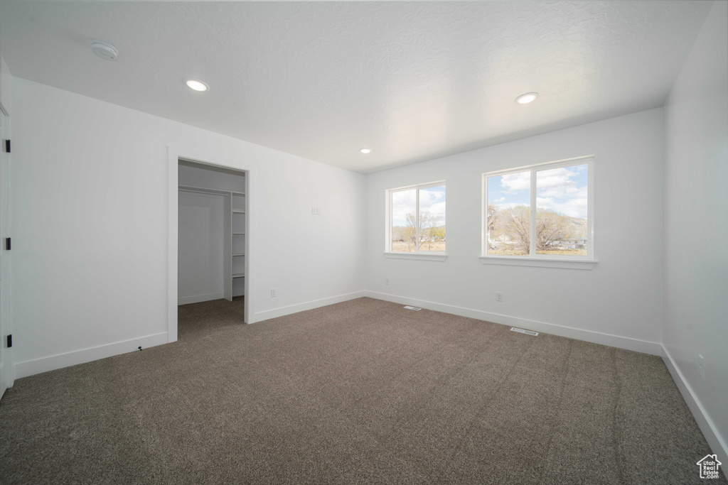 Unfurnished bedroom with a closet and dark colored carpet