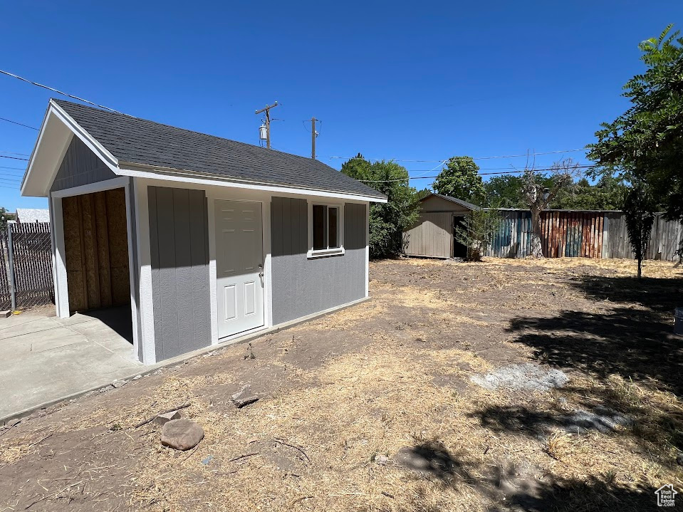 Back of property with a storage shed