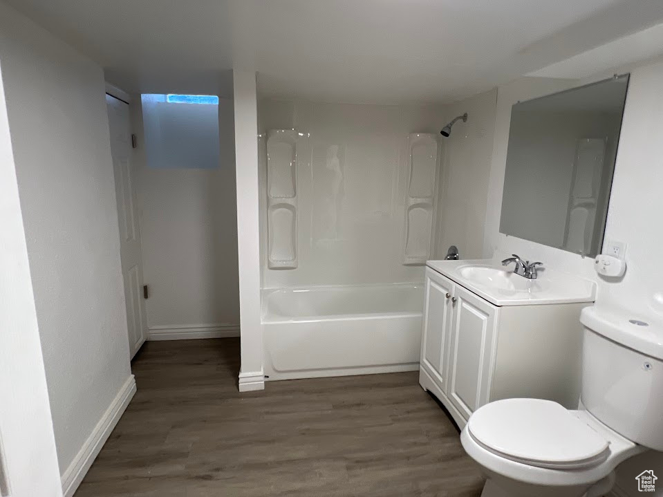 Full bathroom with hardwood / wood-style flooring, bathing tub / shower combination, toilet, and vanity