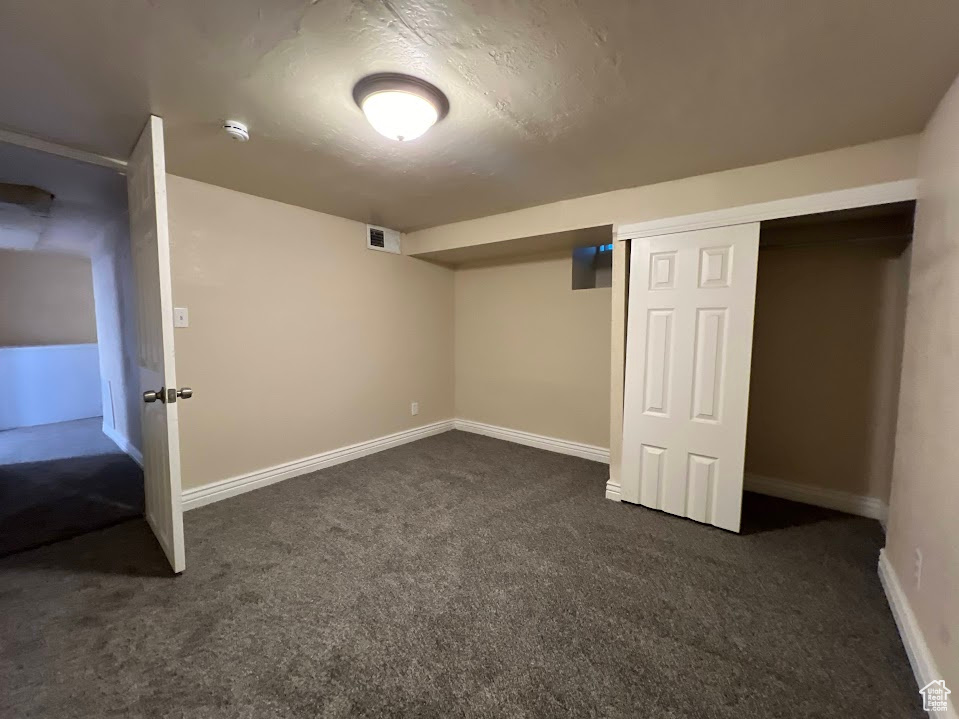 Basement with dark carpet