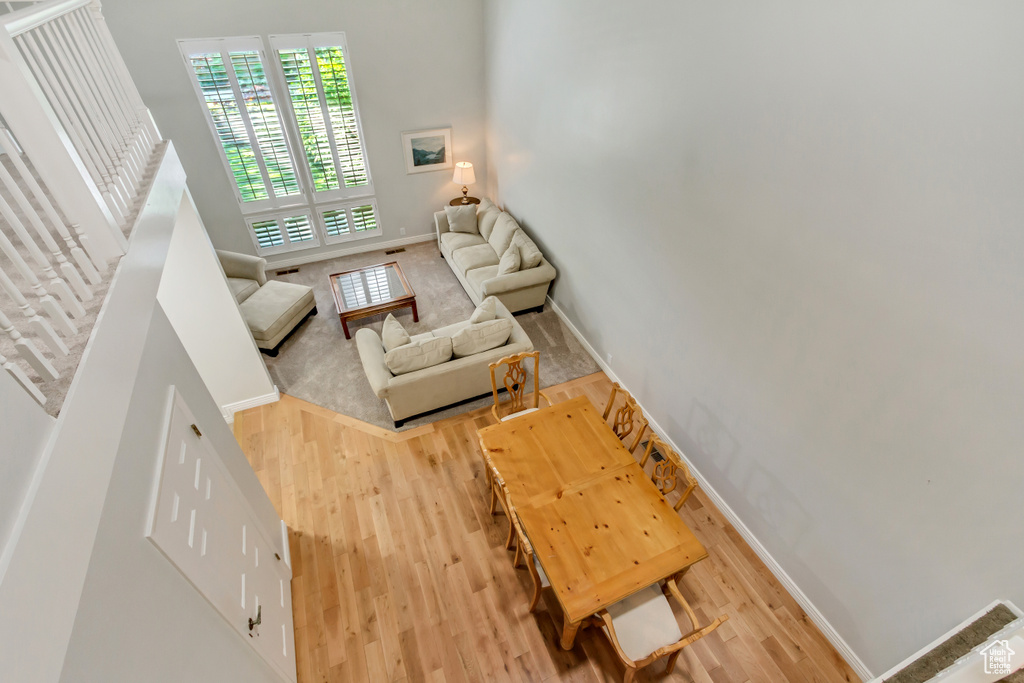 Living room with hardwood / wood-style floors and a towering ceiling