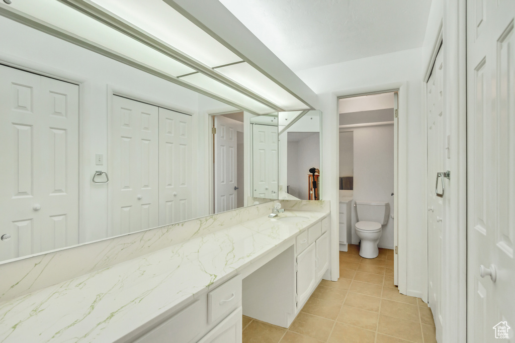 Bathroom featuring tile patterned floors, vanity, and toilet