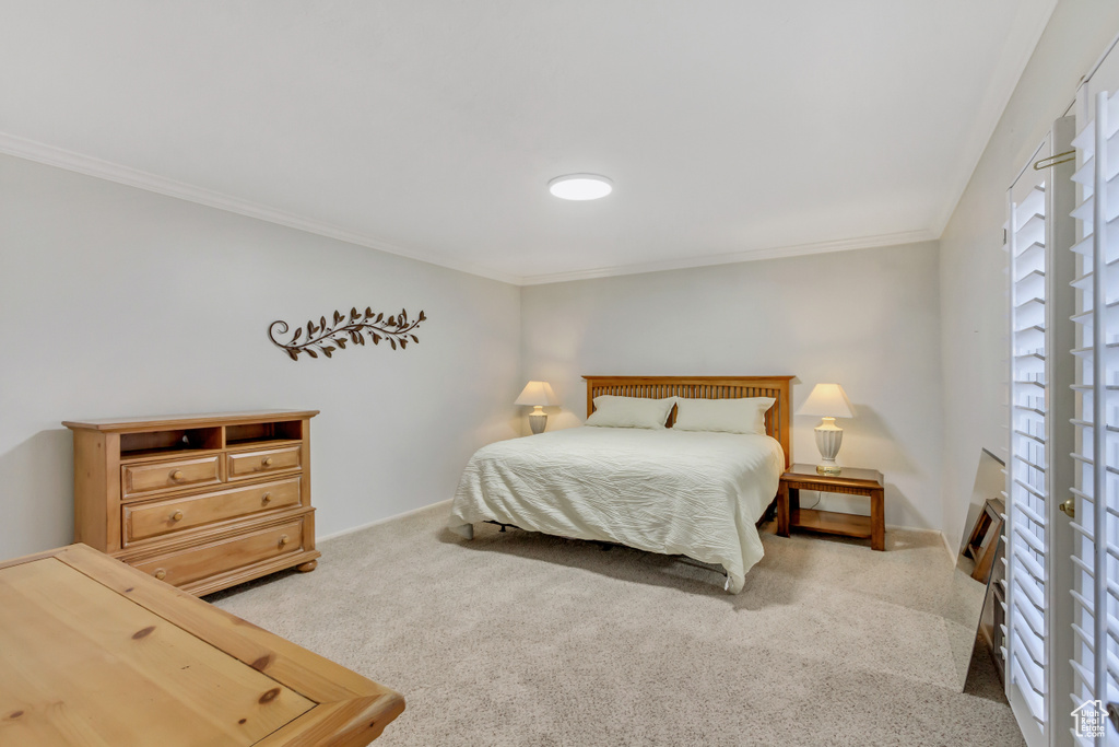 Bedroom with ornamental molding and carpet floors